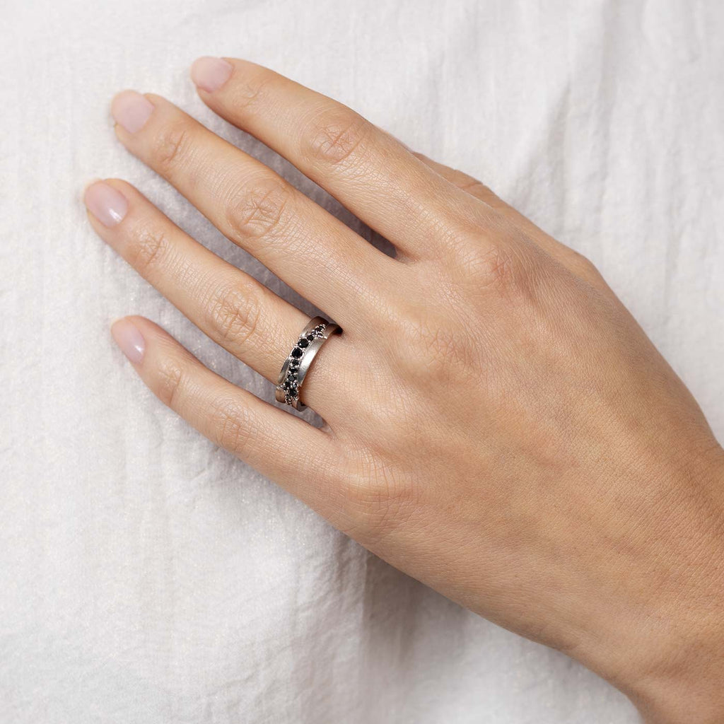 Model wearing a Kymi Stream ring with black diamonds. Design by Tero Hannonen, Au3 Goldsmiths.