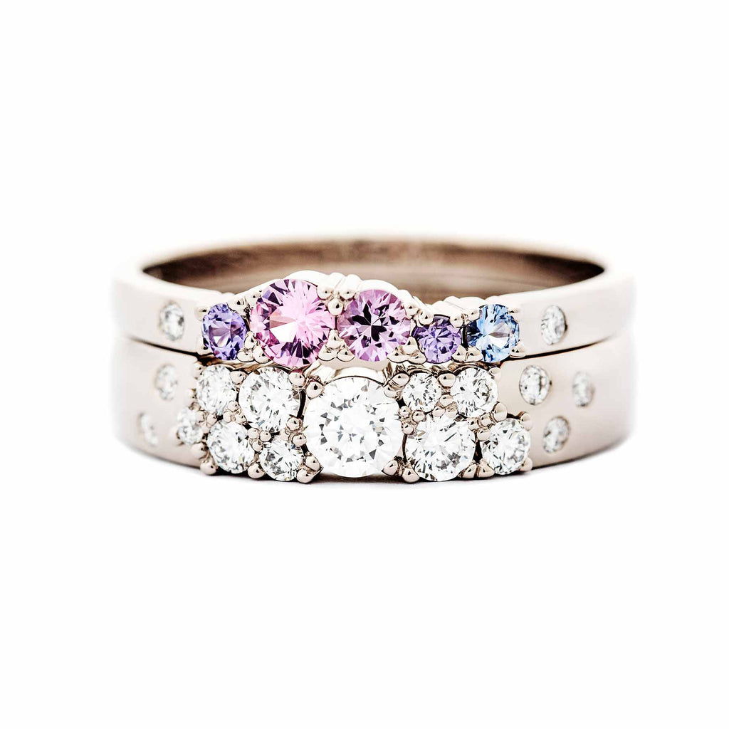 4mm wide Keto Meadow ring with white tw/vs diamonds combined with 2mm wide Keto Meadow pink ring with pink, purple and blue sapphires and white tw/vs diamonds. Both rings are made in 750 white gold. Design by Jussi Louesalmi, Au3 Goldsmiths.
