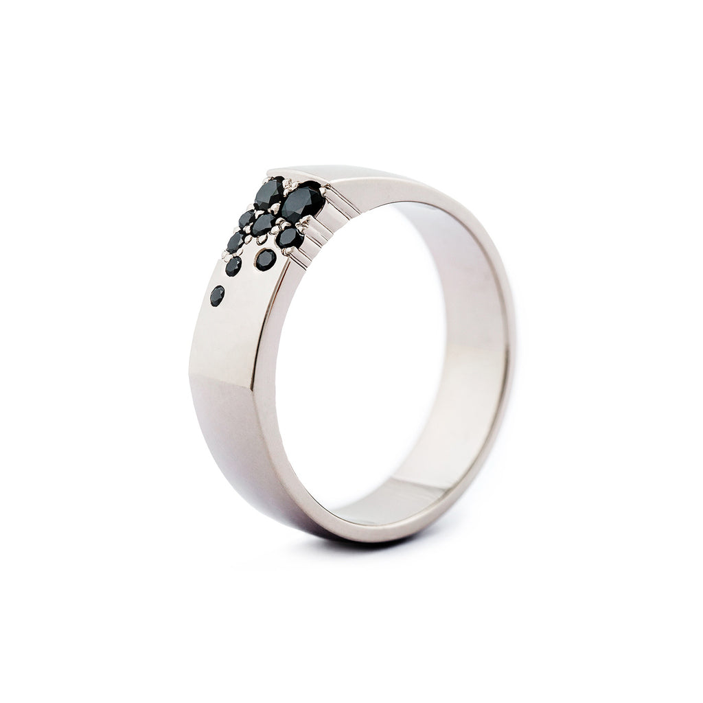 Stylish 6mm wide Kero ring in 750 white gold, with black diamonds placed asymmetrically. Design by Jussi Louesalmi, Au3 Goldsmiths.