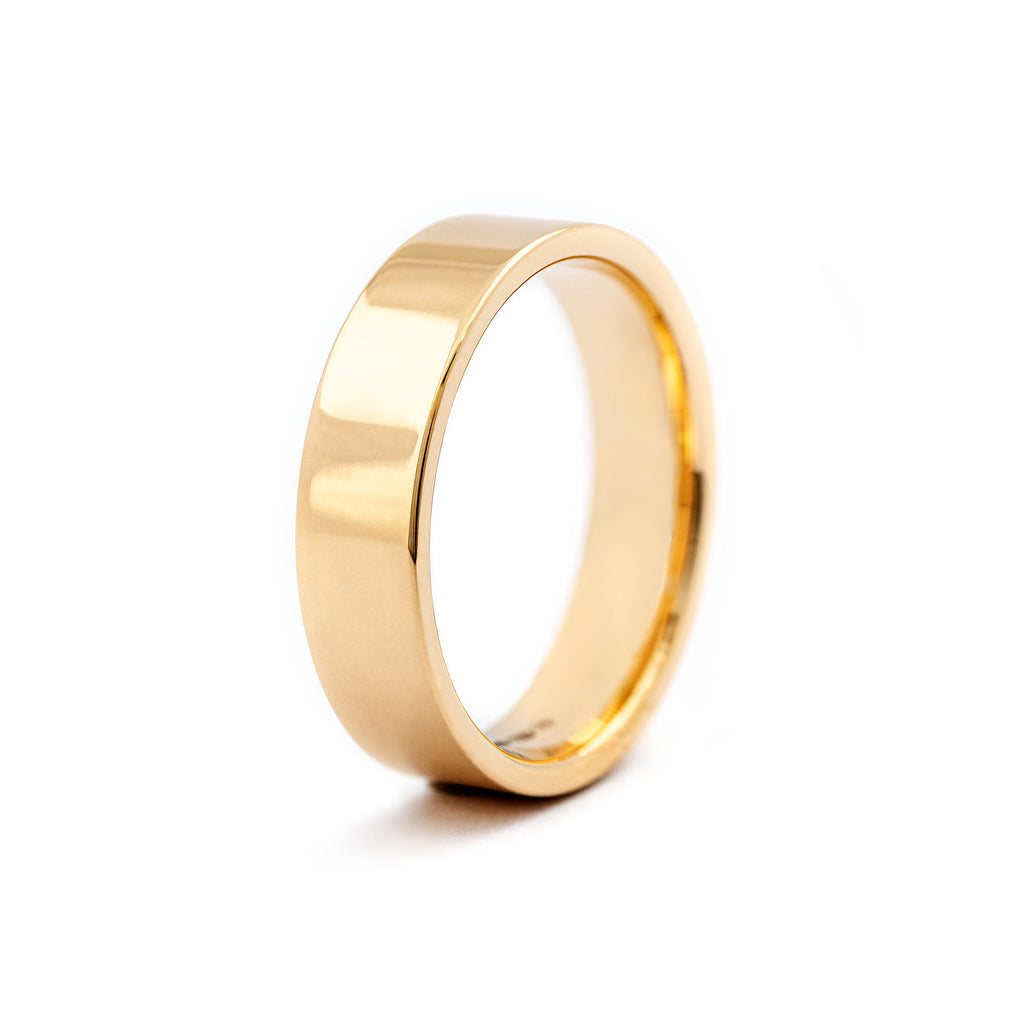Smooth surface in a 6mm wide F6 ring in 18K yellow gold. Design Au3 Goldsmiths.