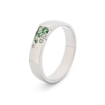 Unisex Kero ring in 18K white gold with asymmetrically placed green diamonds. Design by Jussi Louesalmi, Au3 Goldsmiths.