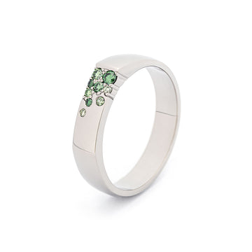 Unisex Kero ring in 18K white gold with asymmetrically placed green diamonds. Design by Jussi Louesalmi, Au3 Goldsmiths.