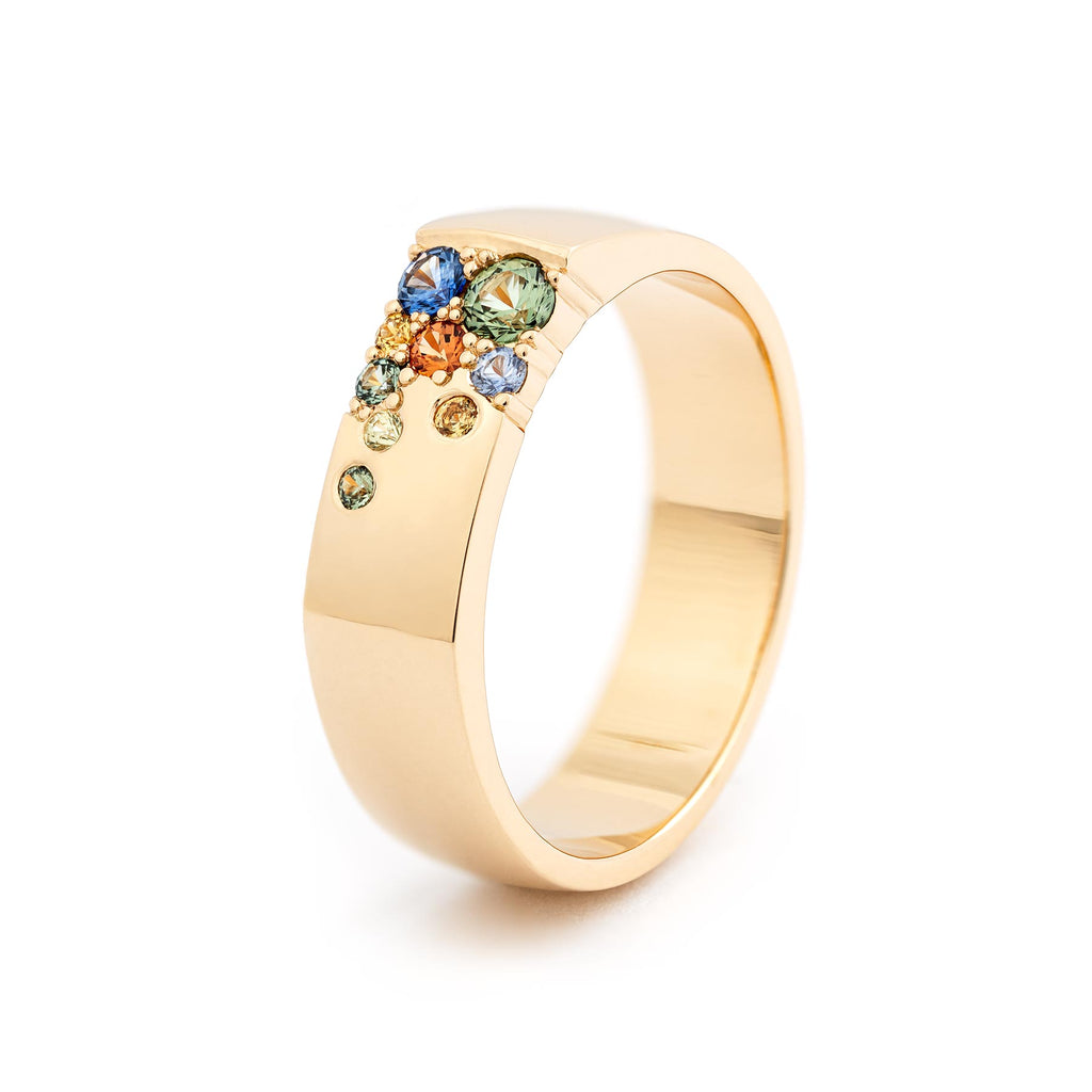 Multiple autumn color sapphires in a 6mm wide ring crafted in 18K yellow gold. Design by Jussi Louesalmi, Au3 Goldsmiths.