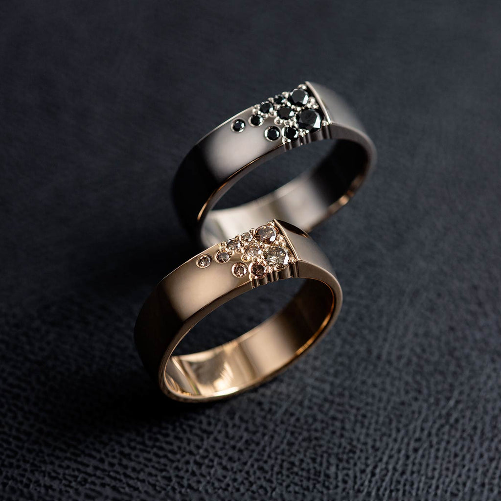6mm wide Kero rings in 18K white gold and yellow gold with multiple black and brown diamonds. Design by Jussi Louesalmi, Au3 Goldsmiths.