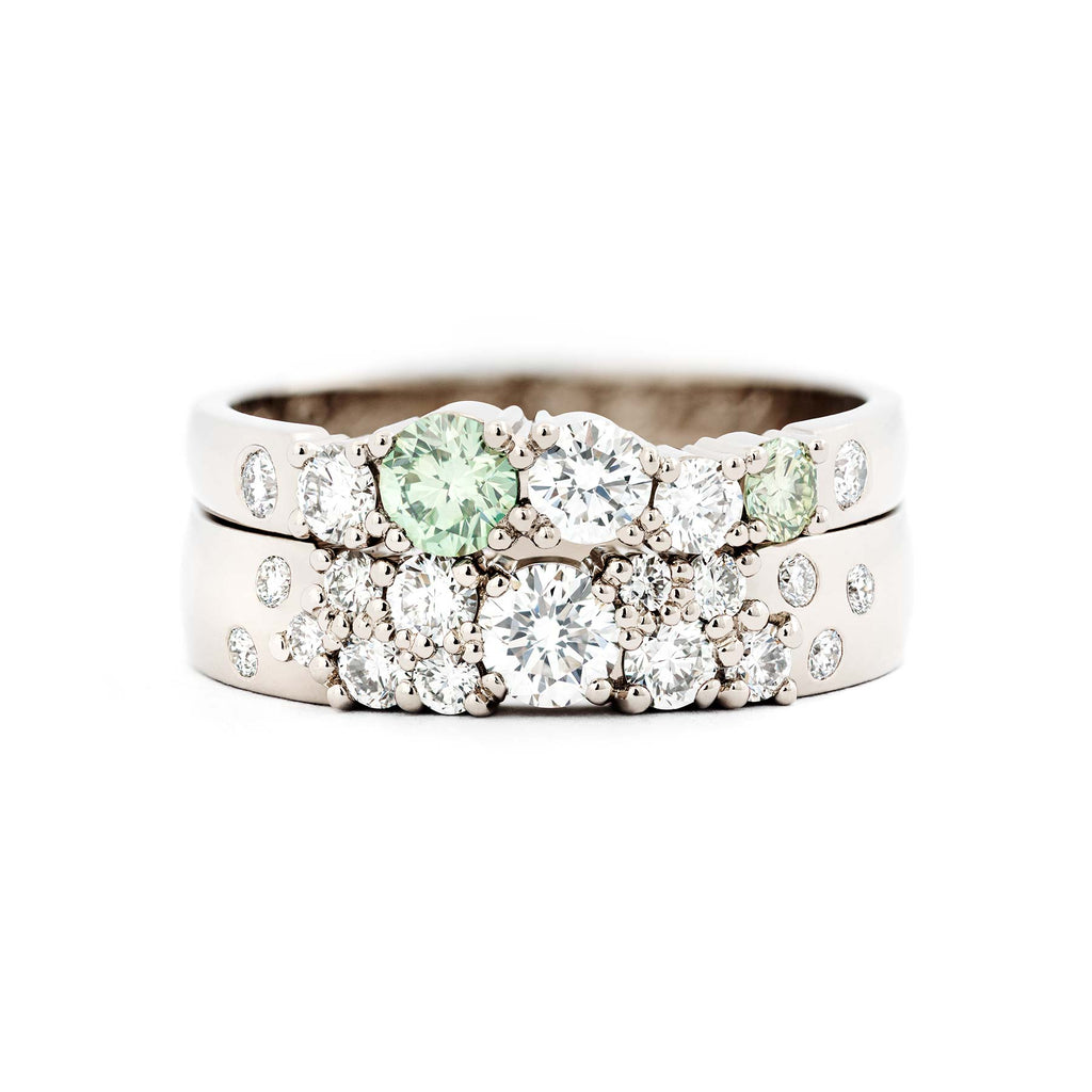 Combination of 2,5mm and 4mm wide rings crafted in recycled 18K white gold with different size white diamonds and light green diamonds. Design Jussi Louesalmi, Au3 Goldsmiths.