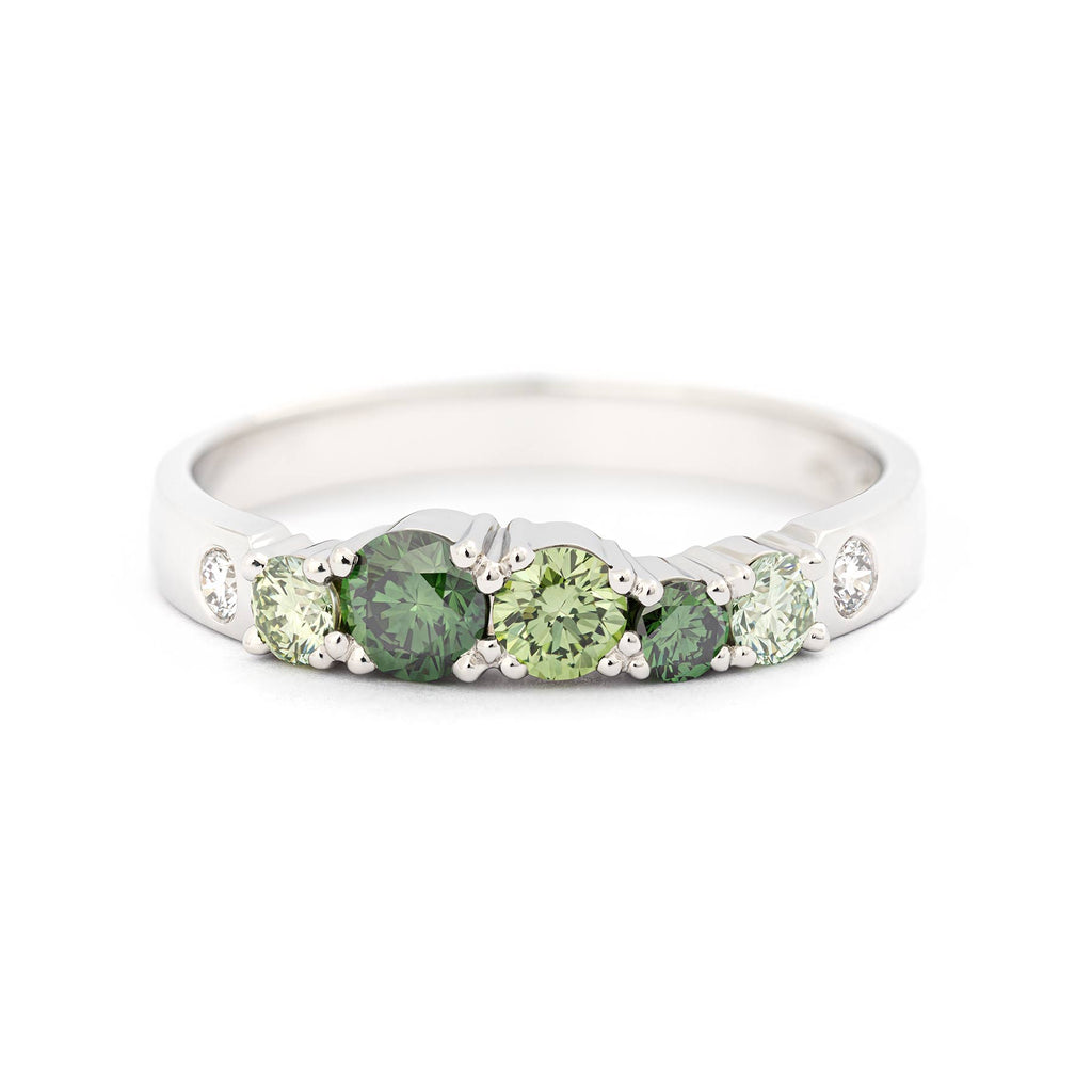 Treated color green diamonds and white tw/vs diamonds in this 2,5mm wide ring in 18K white gold. Design by Jussi Louesalmi, Au3 Goldsmiths.