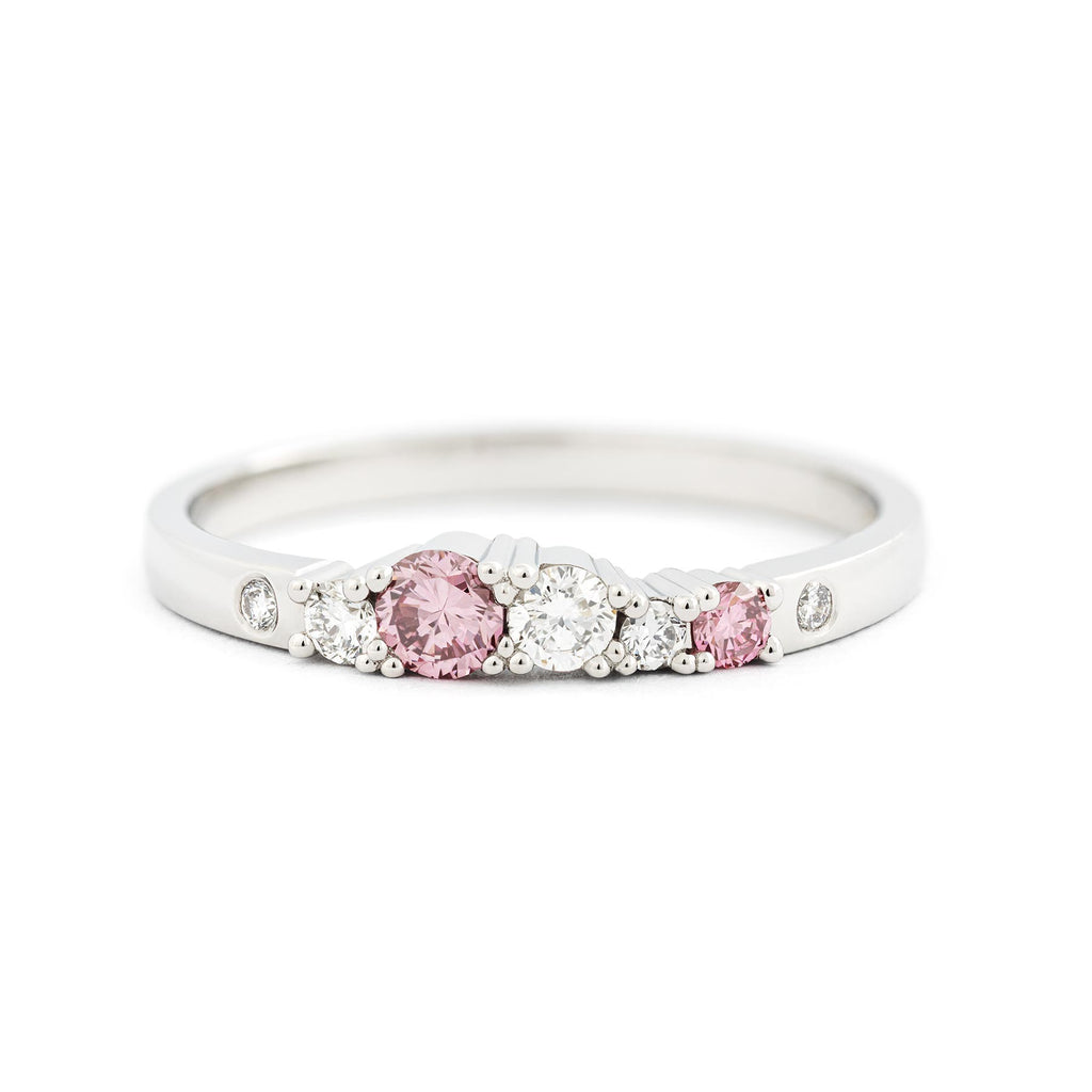 Pink color diamonds and white tw/vs diamonds in the 2mm wide Keto Meadow row ring. Design by Jussi Louesalmi, Au3 Goldsmiths.