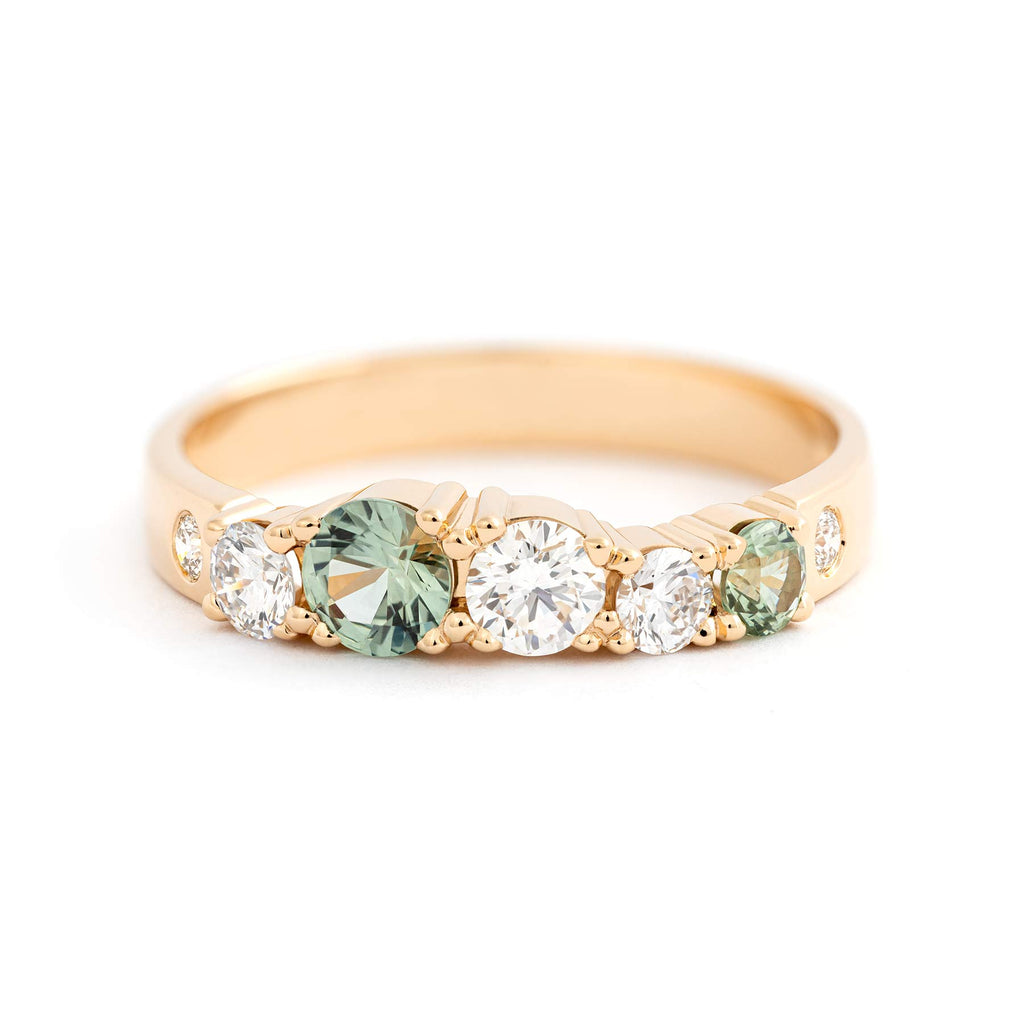 Light green sapphires and white tw/vs diamonds in the 3mm wide ring crafted in 18K yellow gold. Design by Jussi Louesalmi, Au3 Goldsmiths.