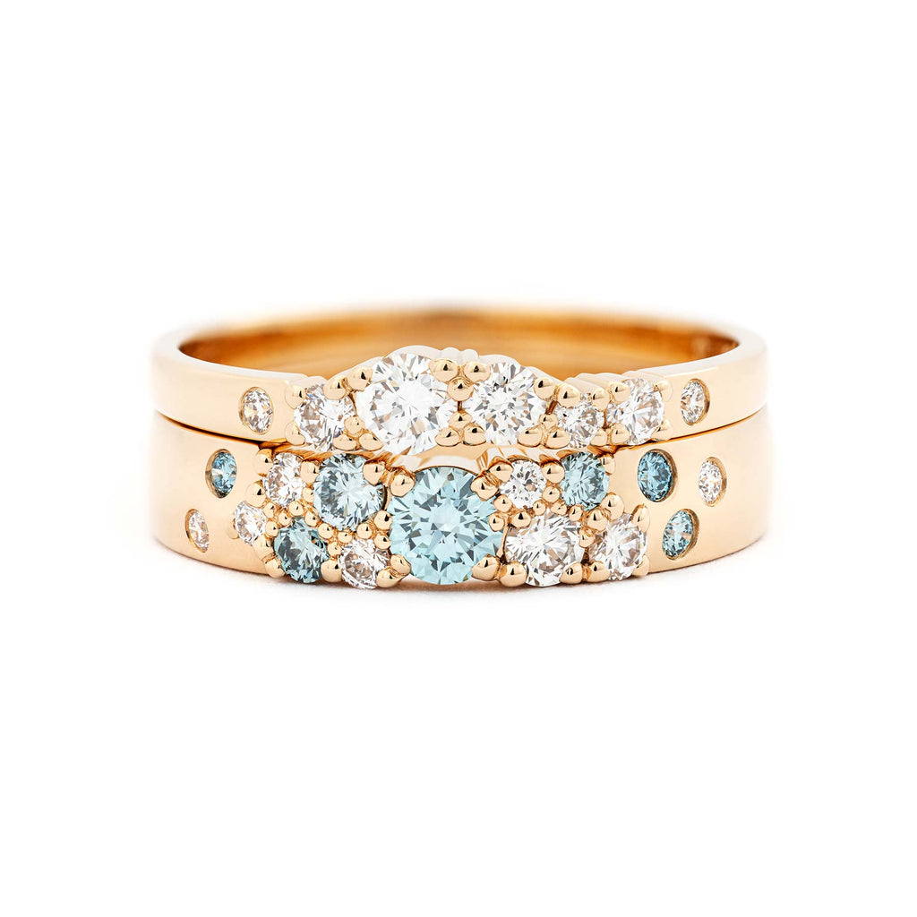Keto Meadow jewelry collection's 4mm wide ring with turquoise Ice Blue diamonds and white diamonds, together with 2mm wide ring with white diamonds, both rings in 18K yellow gold. Design by Jussi Louesalmi, Au3 Goldsmiths.