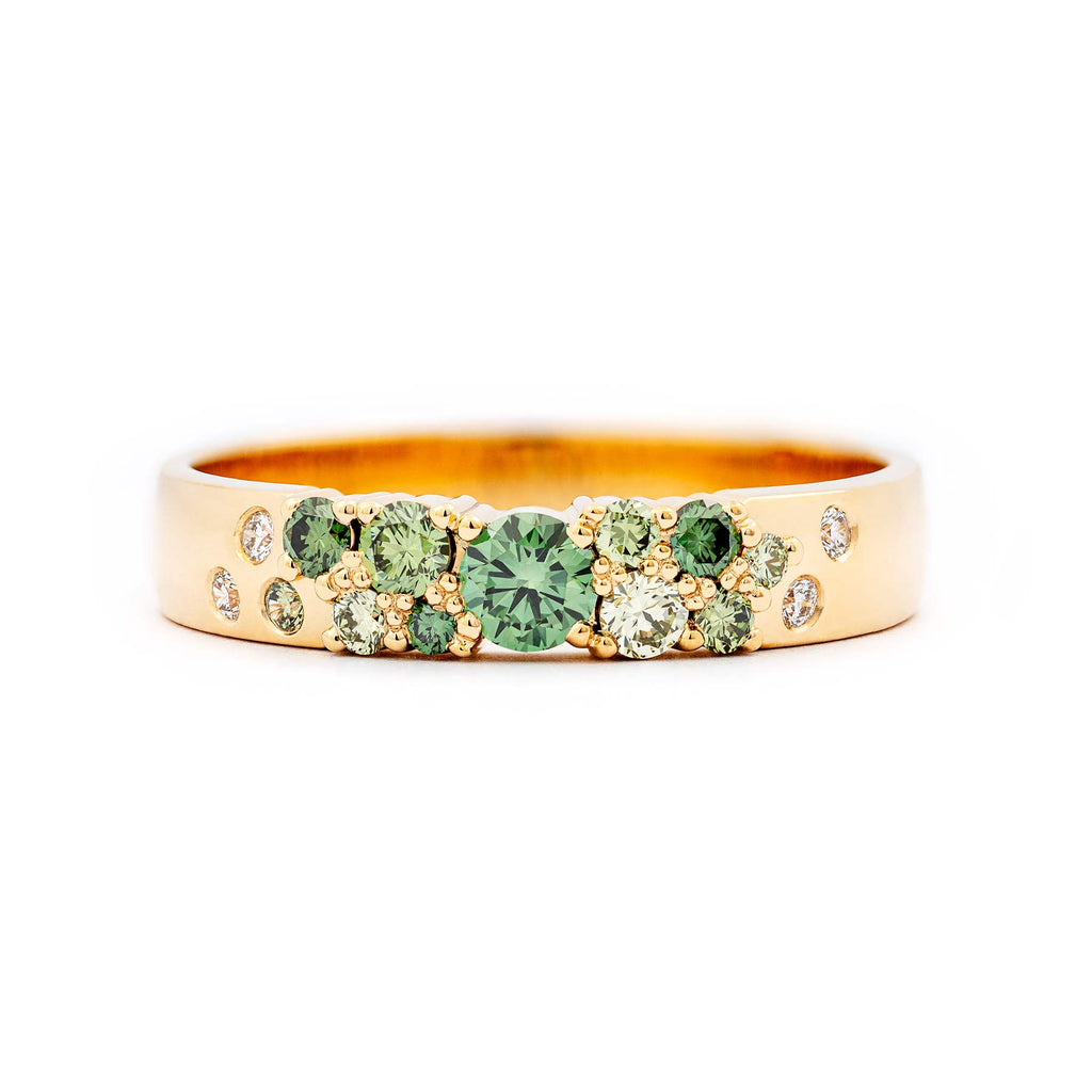Golden 4mm wide Keto Meadow ring with different size green diamonds and small white diamonds. Design by Jussi Louesalmi, Au3 Goldsmiths.