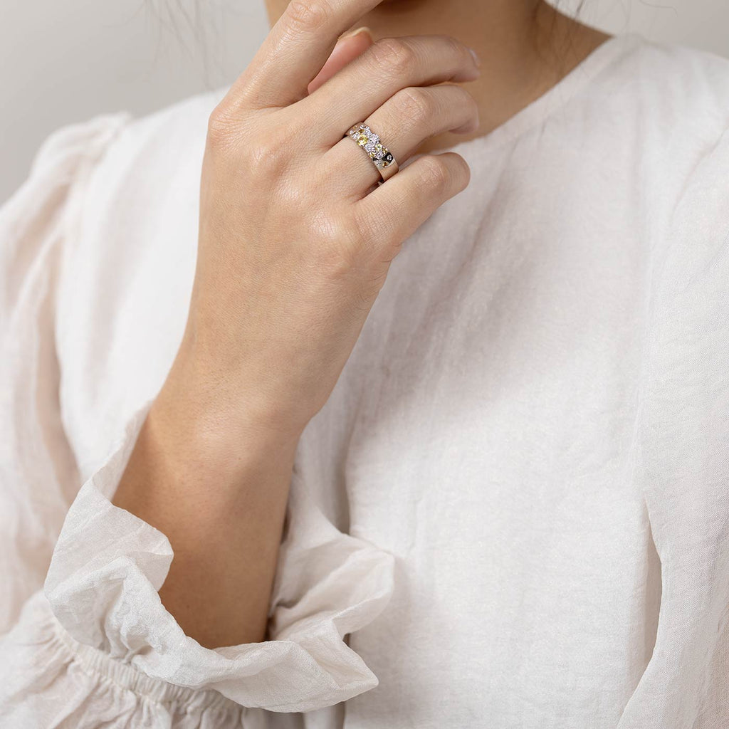 Model wearing a Keto Meadow Spring collection's 6mm wide ring with pastel yellow sapphires and white tw/vs diamonds. Design by Jussi Louesalmi, Au3 Goldsmiths.