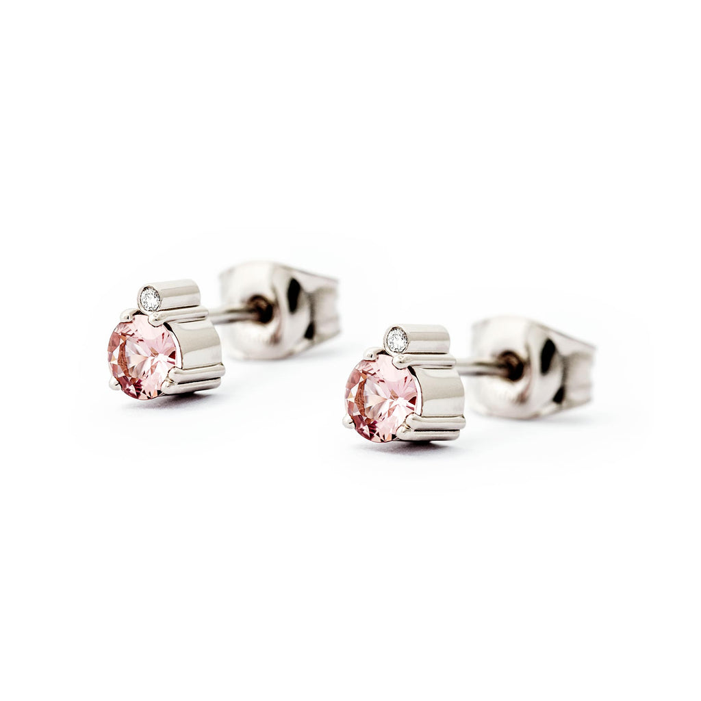 A pair of Keto Meadow earrings, both with one pink sapphire and one white tw/vs diamond, design by Jussi Louesalmi, Au3 Goldsmiths