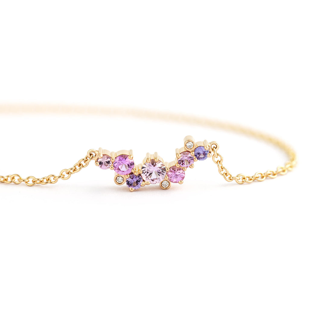 Asymmetrically placed different size colorful sapphires and white diamonds in a Keto Meadow Crown necklace made in 18K yellow gold, design by Jussi Louesalmi, Au3 Goldsmiths.