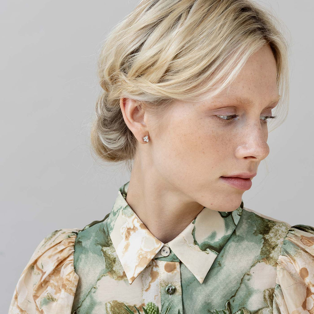 Blond haired model wearing a Keto Meadow stud earring with 4 white diamonds. Design by Jussi Louesalmi, Au3 Goldsmiths.