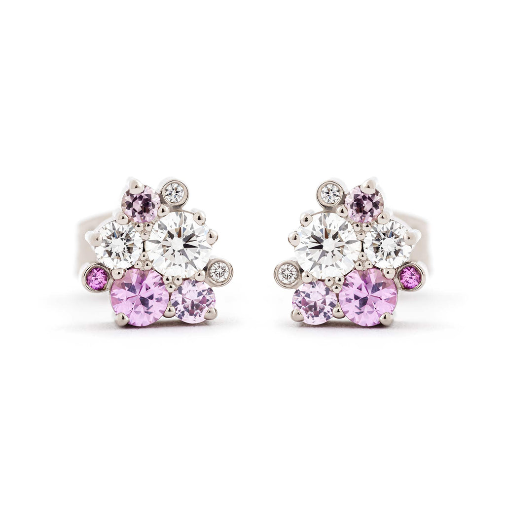 Stud earrings with different size pink sapphires and white tw/vs diamond placed asymmetrically in a cluster. Design by Jussi Louesalmi, Au3 Goldsmiths.