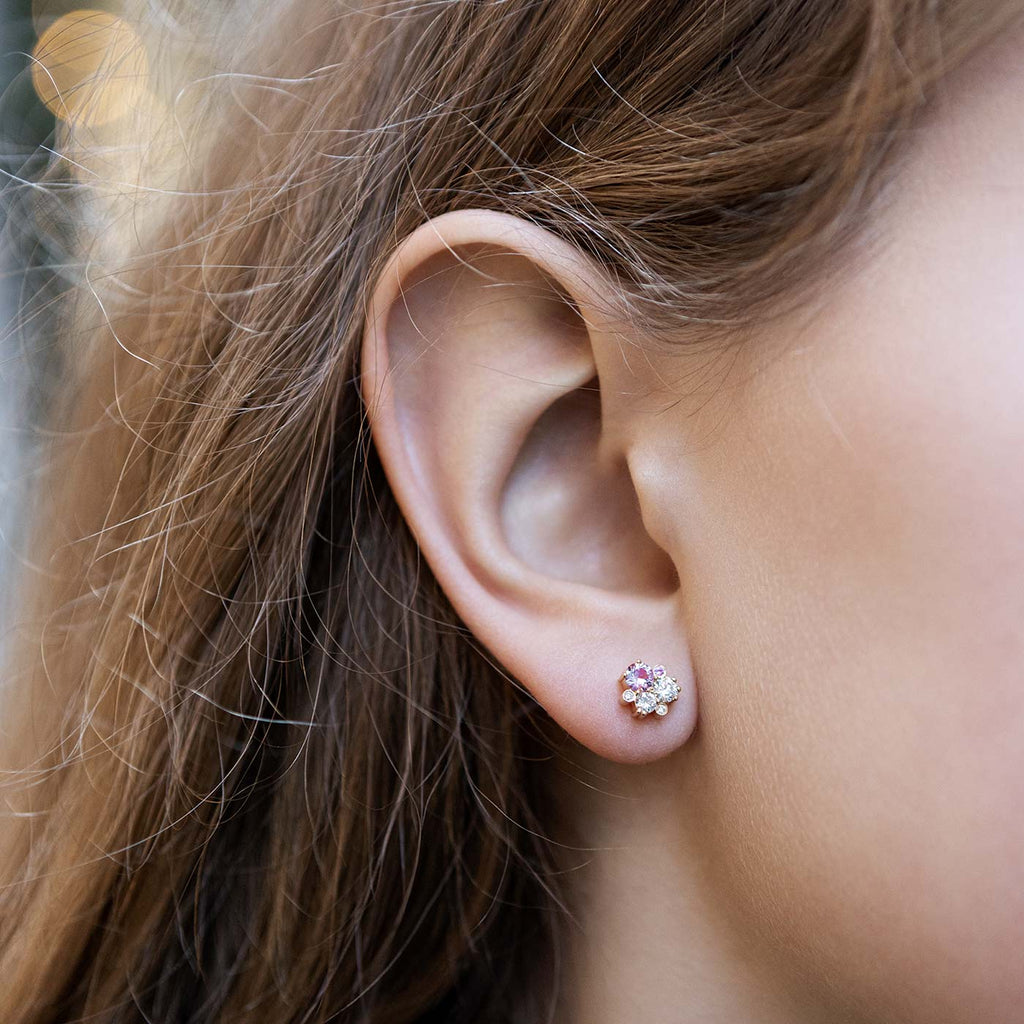 Model wearing a 18K golden Keto Meadow stud earring with pink sapphires and white tw/vs diamonds. Design by Jussi Louesalmi, Au3 Goldsmiths.