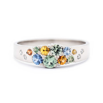 Different size delicious green, orange, blue and yellow sapphires in the narrowing ring model from the Keto Meadow jewelry collection. Design by Jussi Louesalmi, Au3 Goldsmiths. 