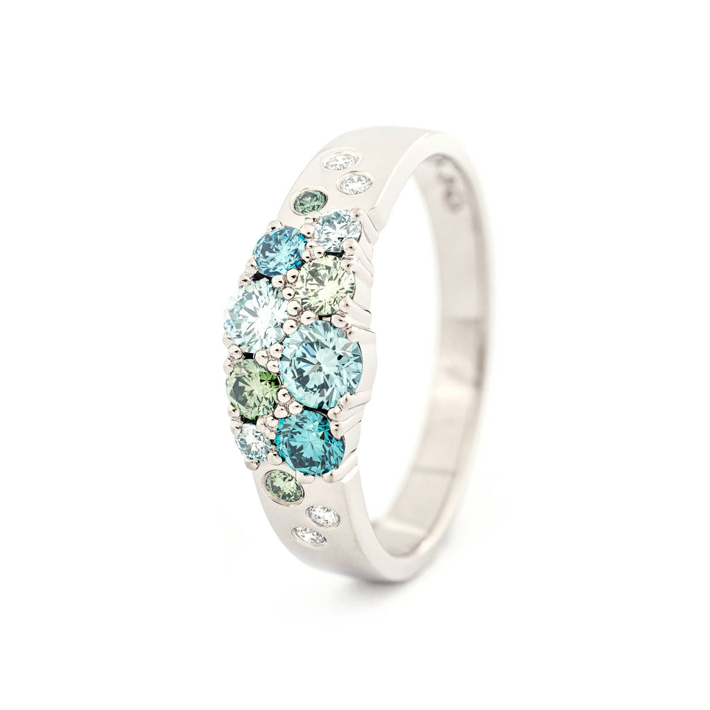 Different size turquoise and green diamonds with white diamonds in the narrowing Keto Meadow ring made in 18K white gold. Design by Jussi Louesalmi, Au3 Goldsmiths.