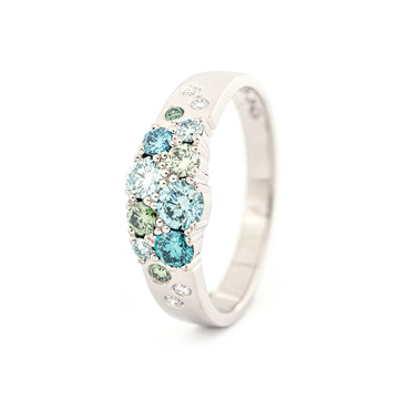 Different size turquoise and green diamonds with white diamonds in the narrowing Keto Meadow ring made in 18K white gold. Design by Jussi Louesalmi, Au3 Goldsmiths.