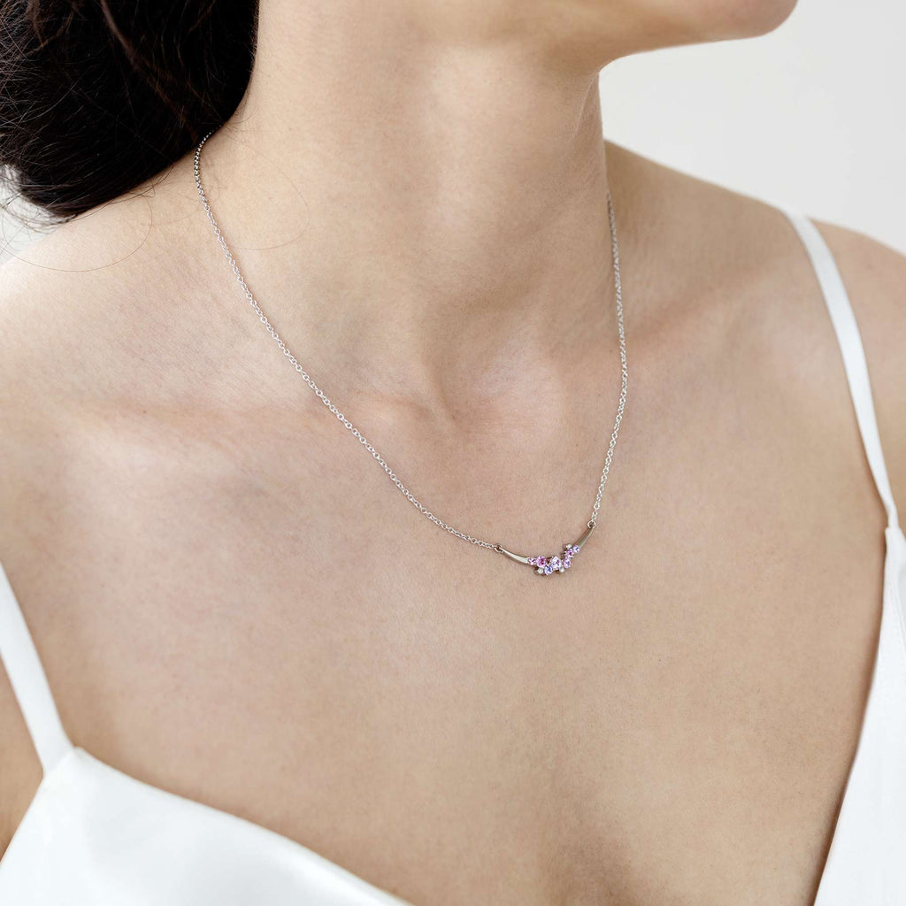 Model wearing a Keto Meadow Crown Arc necklace crafted in 18K white gold  adorned with sapphires and white diamonds. Design by Jussi Louesalmi, Au3 Goldsmiths.