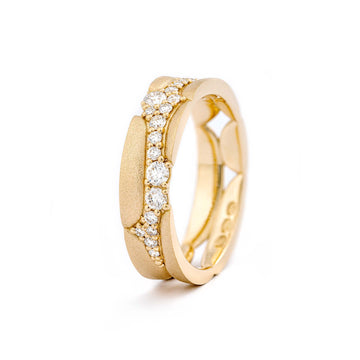 A sculptural Kymi ring in 18K yellow gold by goldsmith Tero Hannonen, made with different size white diamonds arranged like a stream running between stones.