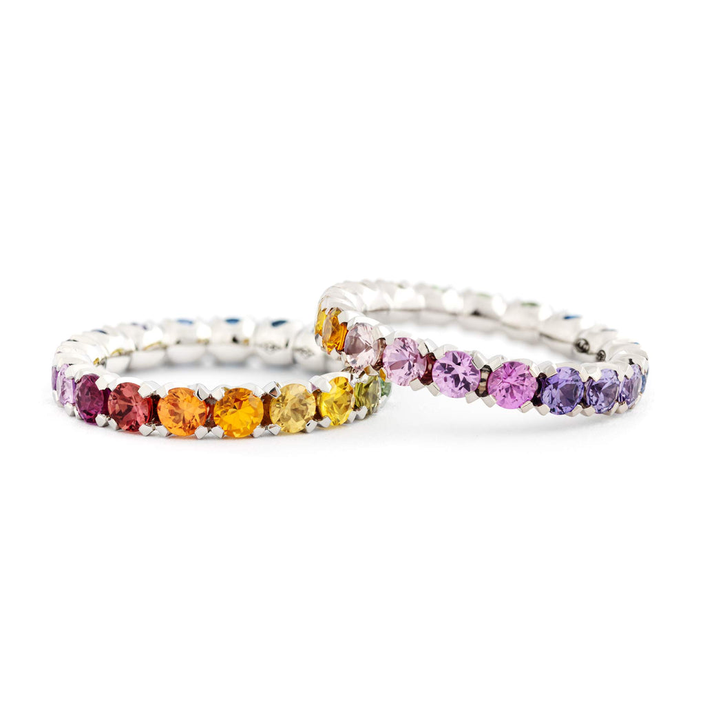 A pair of Rainbow alliance rings crafted from 18K white gold with colorful sapphires. Design by Jussi Louesalmi, Au3 Goldsmiths.