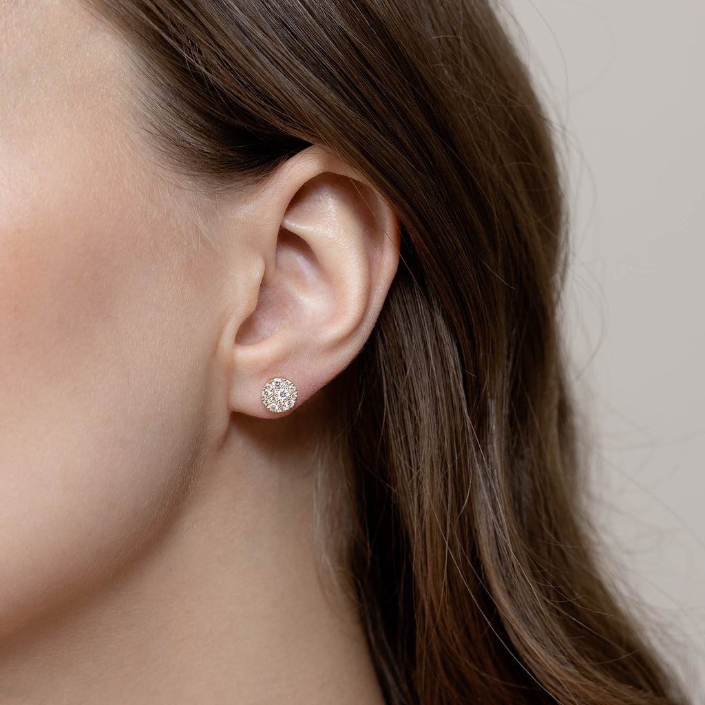 Brown haired model wearing Cupcake stud earrings in which the different size diamonds are assembled into a cluster. Design by Jussi Louesalmi, Au3 Goldsmiths.