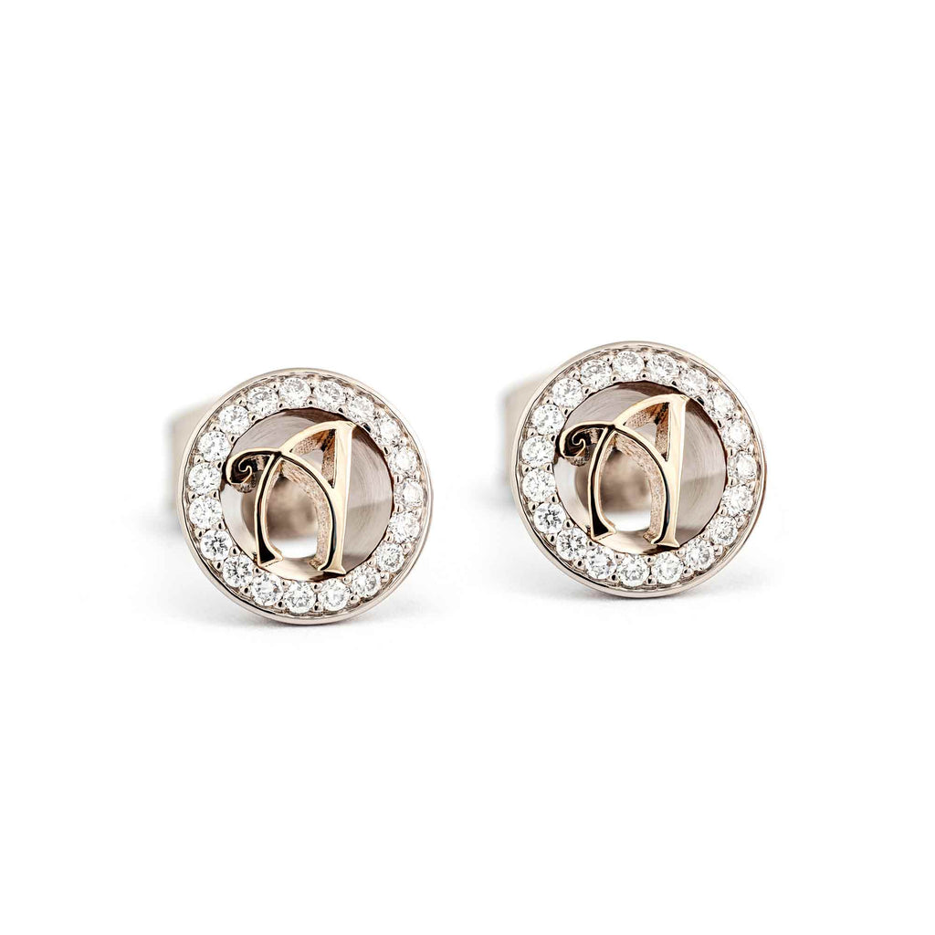 Grammi stud earrings: round monogram with two letters made in 750 yellow gold in the middle, circle of diamonds around the monogram. Material of the earrings 750 white gold. Design Tero Hannonen, Au3 Goldsmiths.