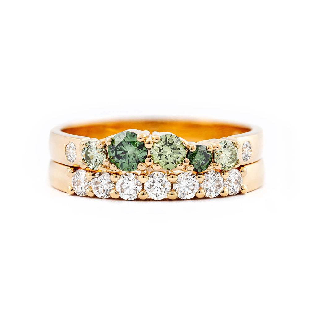 Combination of a Keto Meadow 2,5mm green with green and white diamonds and a Raita 2,5mm wide ring with white diamonds. Both in 750 yellow gold. Design by Jussi Louesalmi, Au3 Goldsmiths.