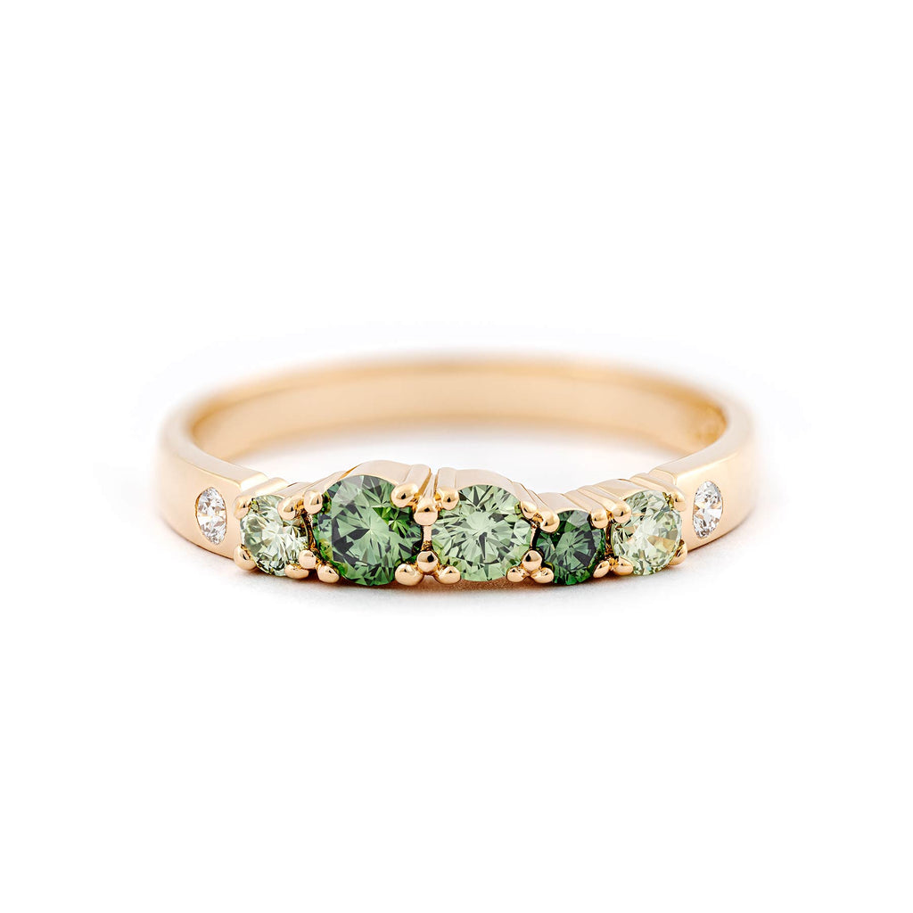 Vivid green diamonds and white tw/vs diamonds in this 2,5mm wide ring in glowing gold. Design by Jussi Louesalmi, Au3 Goldsmiths.