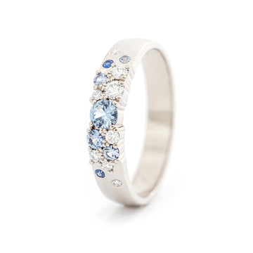  Keto Meadow Spring collections 4mm wide ring in 750 white gold, with asymmetrically placed pastel blue sapphires and white diamonds. Design by Jussi Louesalmi Au3 Goldsmiths.