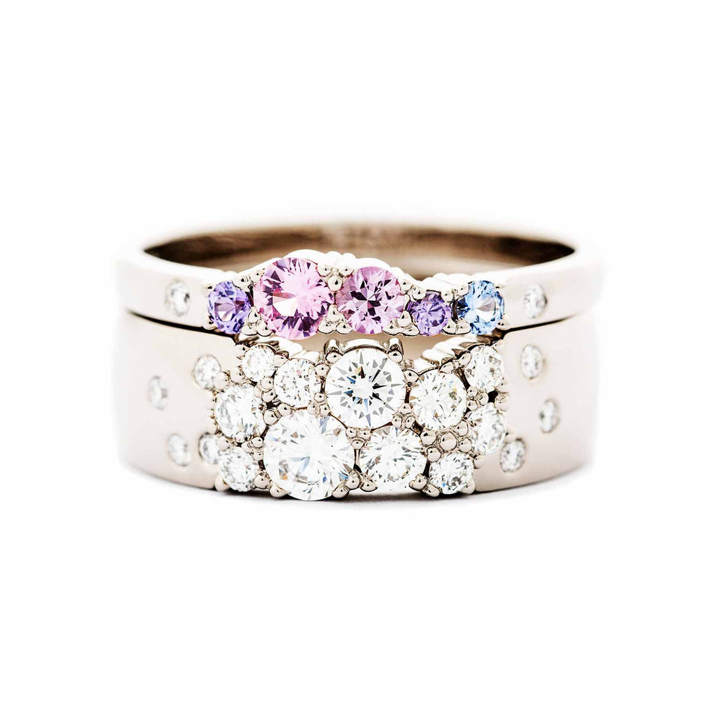 Keto Meadow 6mm wide ring with white tw/vs diamonds together with 2mm wide Keto meadow ring with pink, purple and blue sapphires and white tw/vs diamonds. Both rings are made in 750 white gold. Design by Jussi Louesalmi, Au3 Goldsmiths.