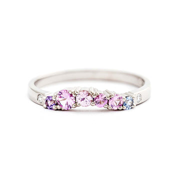 Keto Meadow Arc ring with pink, blue and violet sapphires and white diamonds. Suits well next to a narrowing Keto Meadow ring, or a solitaire ring. Design by Jussi Louesalmi, Au3 Goldsmiths