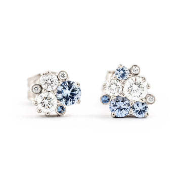 An asymmetrical pair of Keto meadow stud earrings with pastel blue sapphires and white diamonds. Design by Jussi Louesalmi, Au3 Goldsmiths.