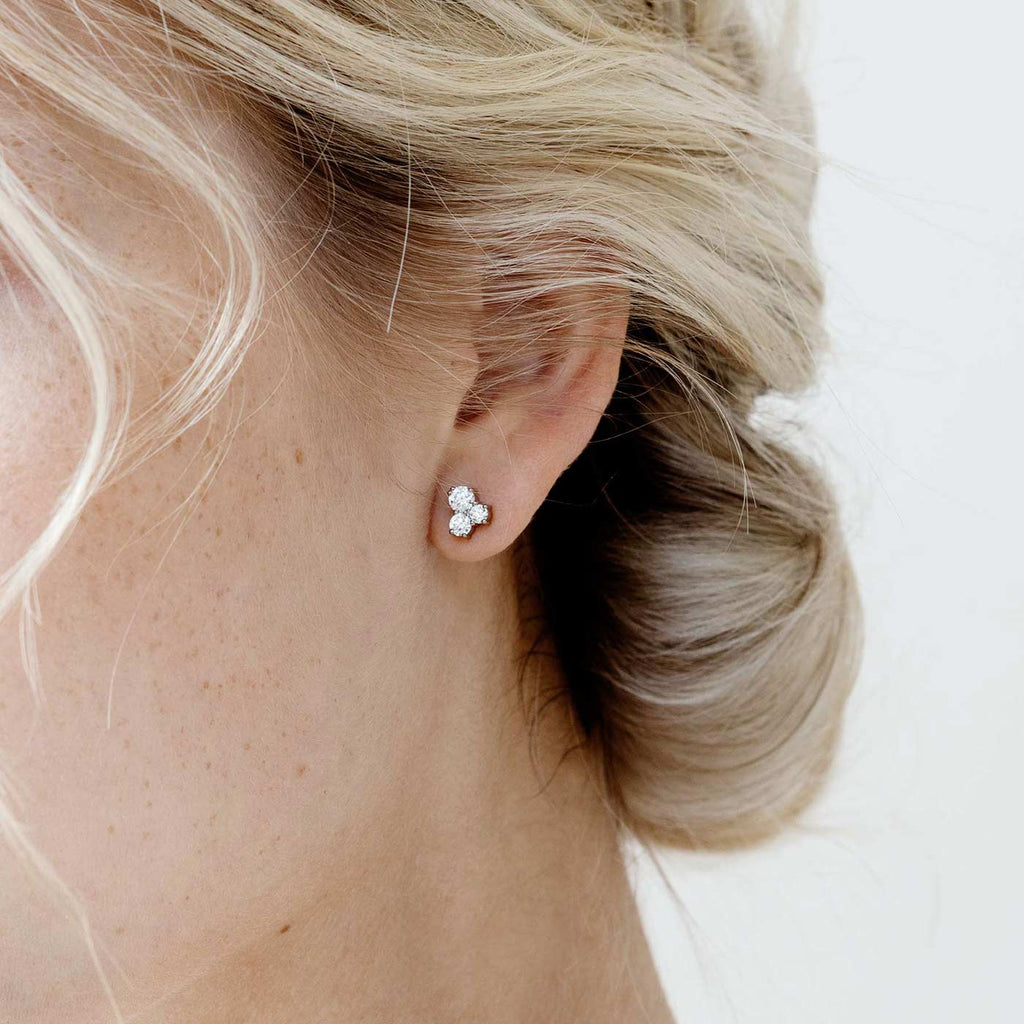 Model wearing a Keto Meadow stud earring where is 3 white diamonds. Design by Jussi Louesalmi, Au3 Goldsmiths.
