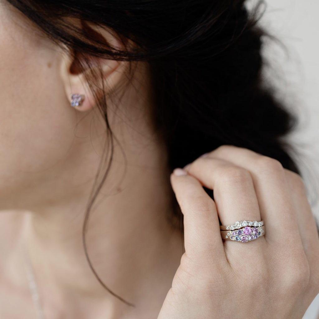 Model wearing a combination of the Keto Meadow narrowing ring with pink, blue and violet sapphires and white diamonds and the Keto Meadow Arc ring with white diamonds. Design by Jussi Louesalmi, Au3 Goldsmiths.