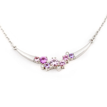 Keto Meadow Crown Arc necklace has 7 asymmetrically placed different size sapphires and 3 white diamonds. Design by Jussi Louesalmi, Au3 Goldsmiths.