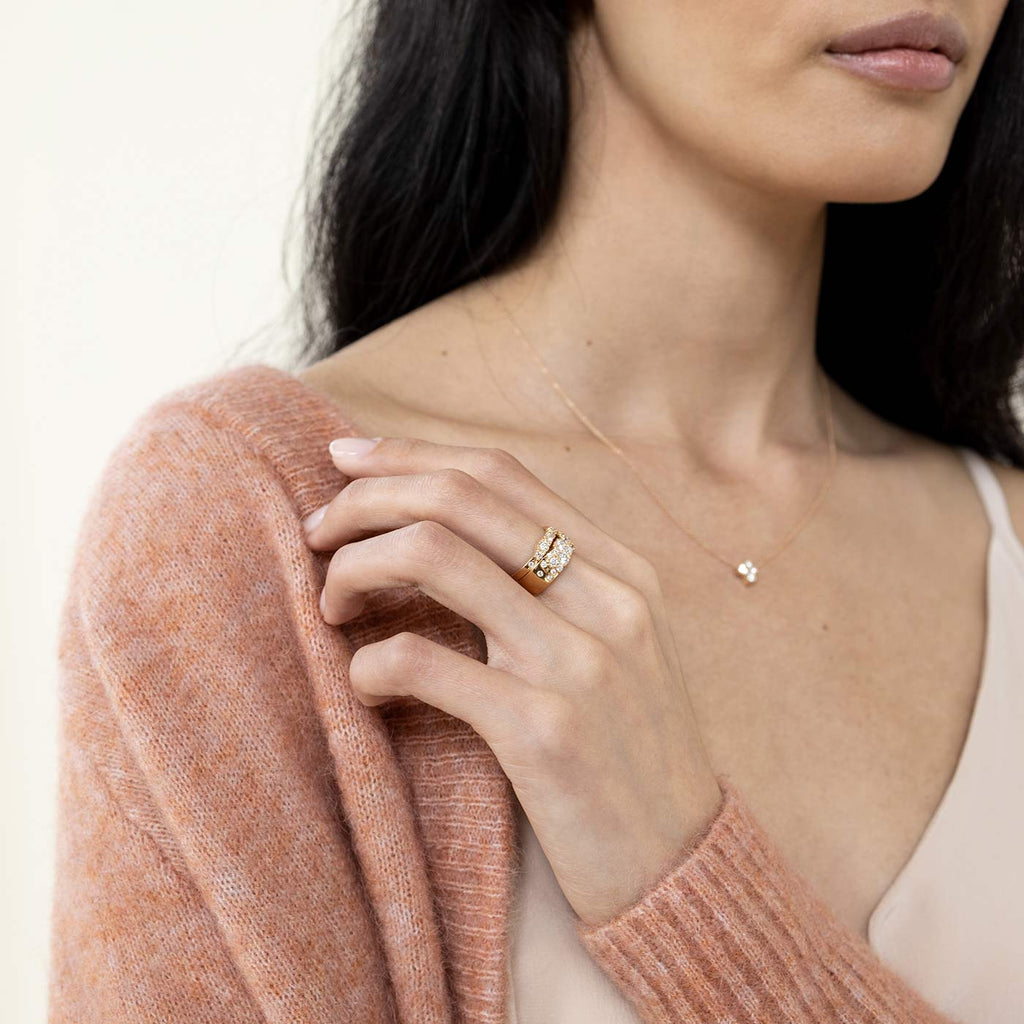 Model wearing 6mm and 2mm wide Keto Meadow yellow gold rings with white diamonds. Design by Jussi Louesalmi, Au3 Goldsmiths.